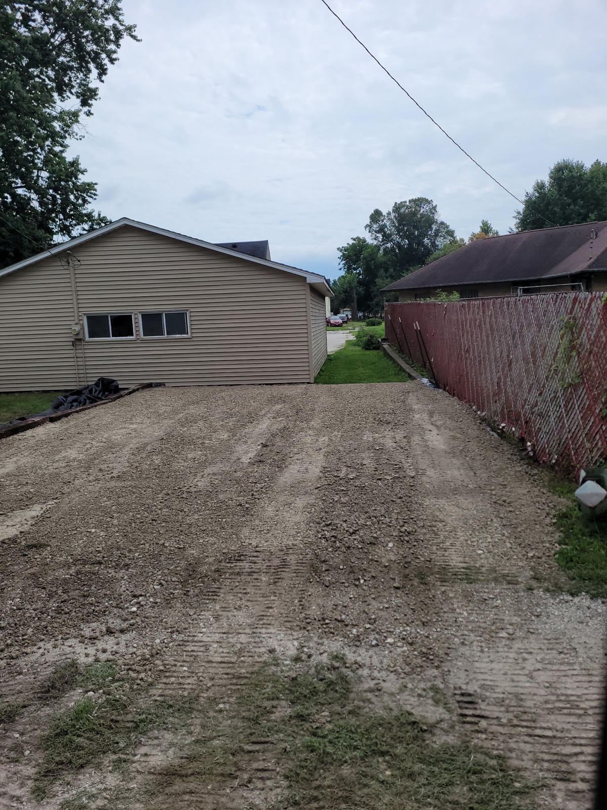 CA6 crushed stone spread on a pad beside a garage in Arcola, IL — Brohez Trucking LLC