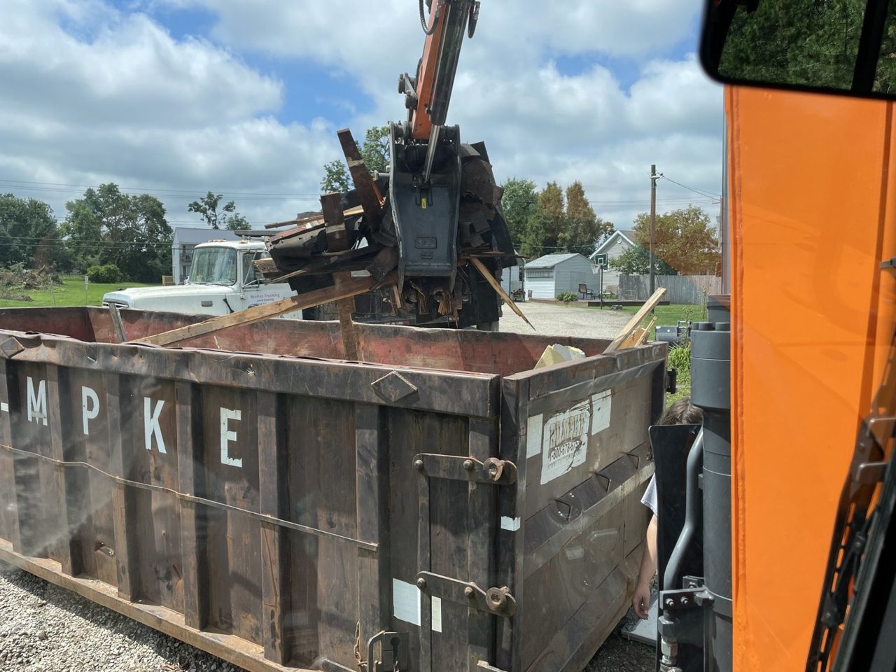 Excavator loading demolition debris into a roll-off dumpster in central Illinois — Brohez Trucking LLC