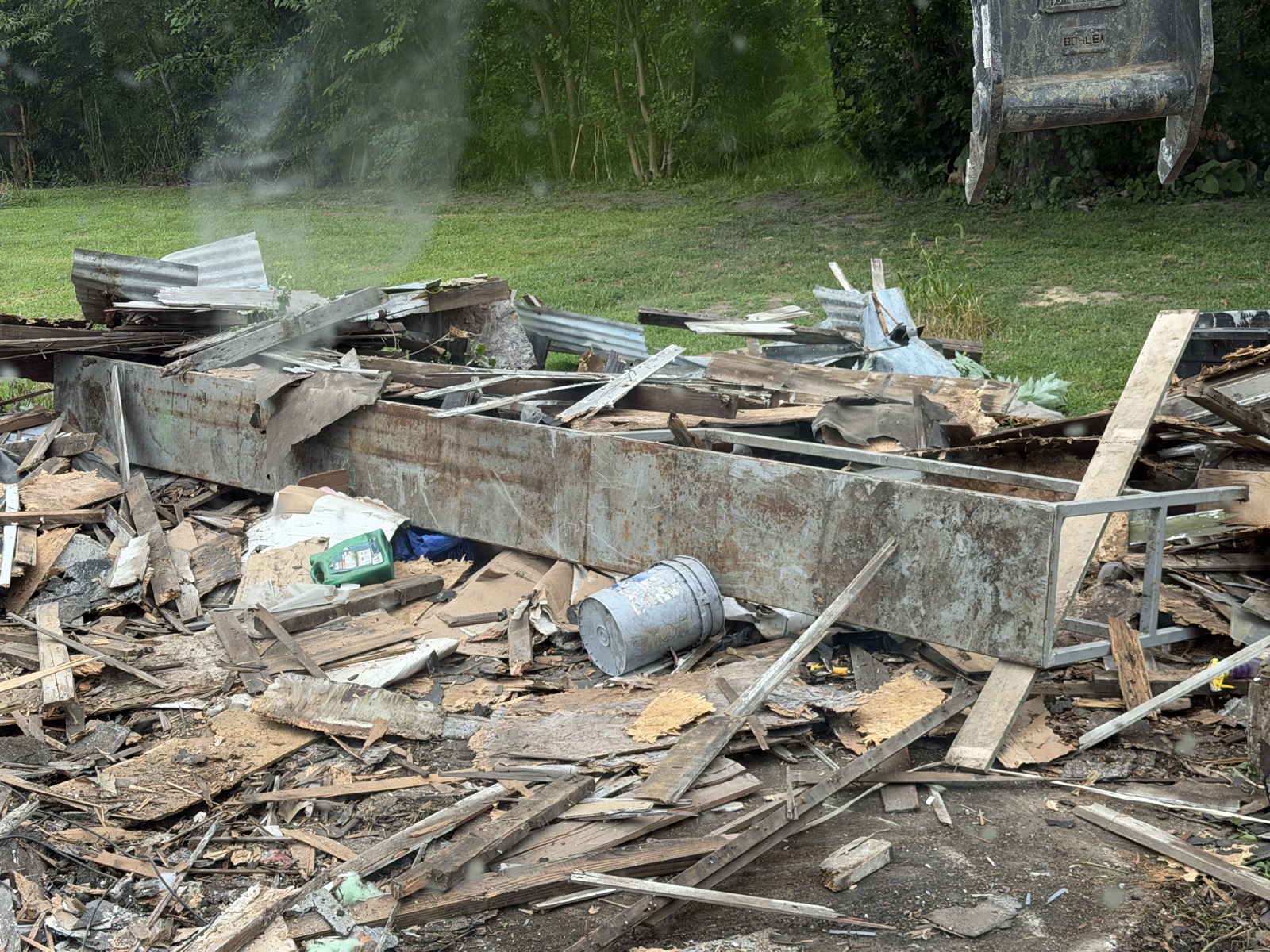 Detached garage torn down to a debris pile of lumber, tin, and steel beam in Mattoon, IL — Brohez Trucking LLC