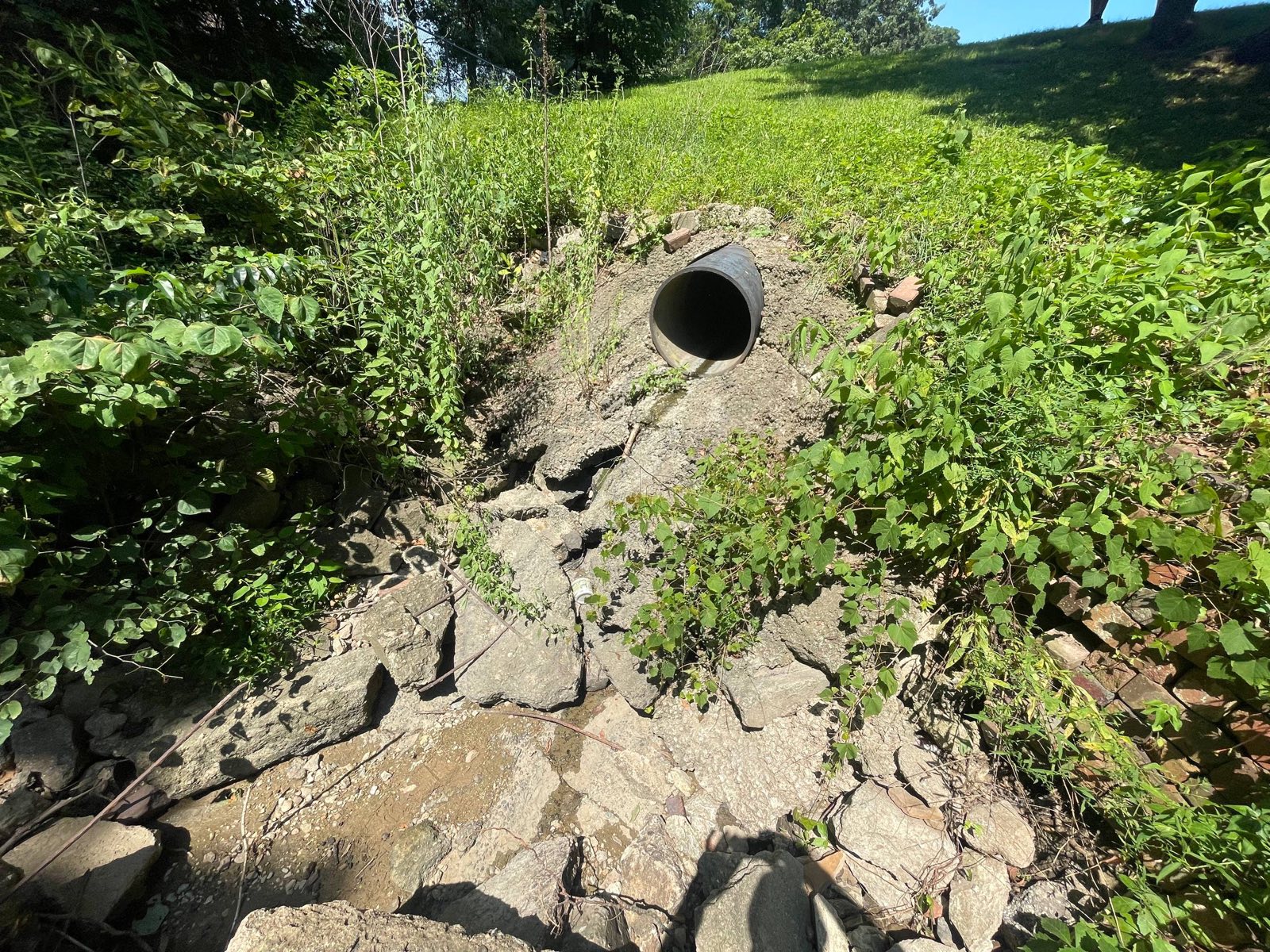 Pond dam outlet pipe with a cracked, undercut concrete apron on a dam repair near Decatur, Illinois — Brohez Trucking LLC