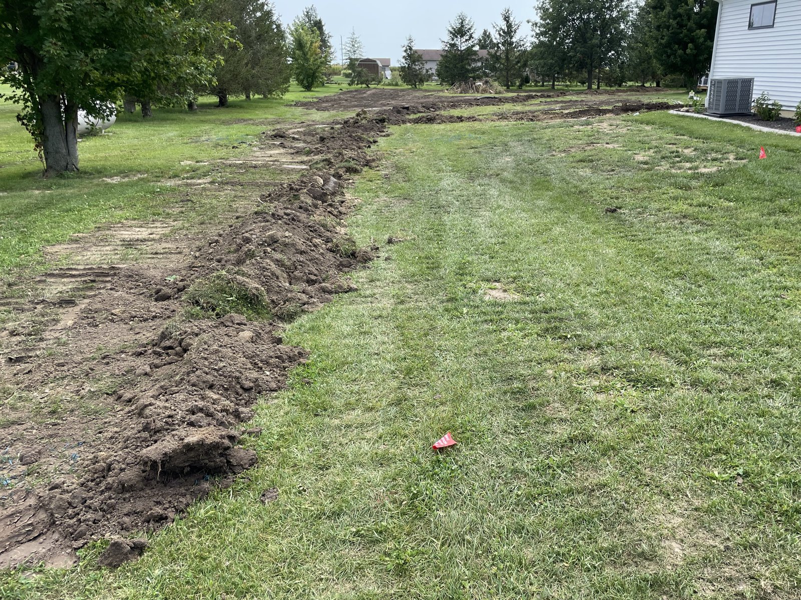 Backfilled drain tile trench lines across a residential lawn in Tolono, IL — Brohez Trucking LLC